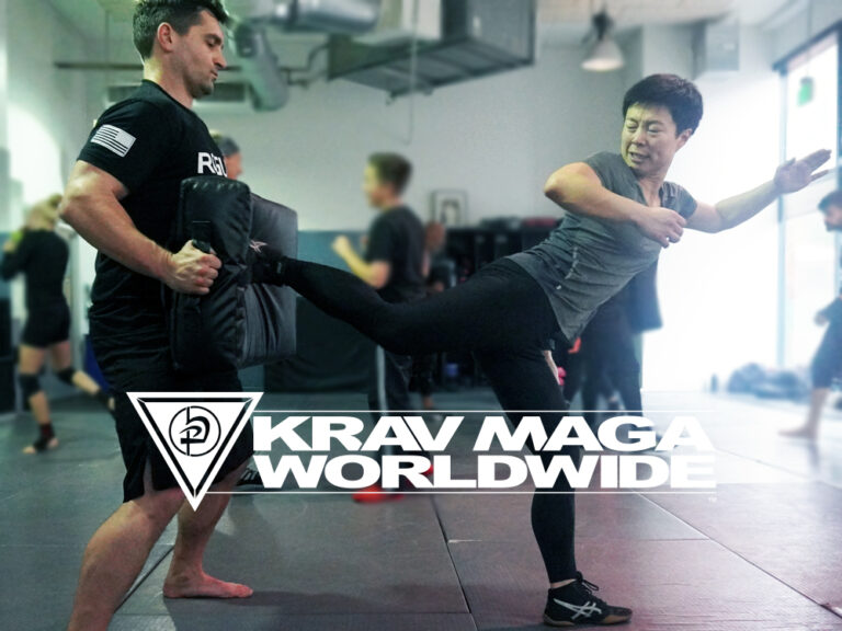Woman making a side kick in Krav Maga self-defense class.